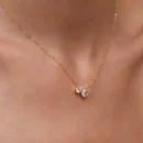 Delicate gold necklace with round and pear-shaped stone pendant on neck