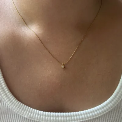 Small crystal pendant necklace styled with a white outfit