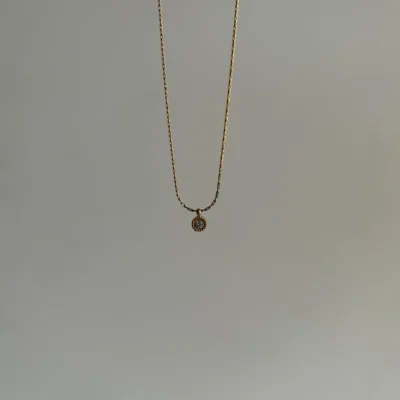 Small crystal pendant necklace styled with a white outfit