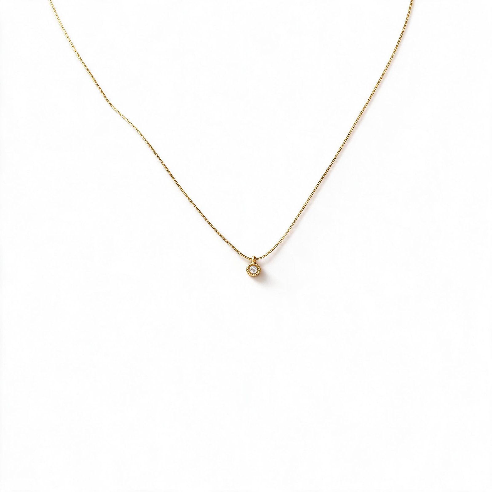 Dainty gold necklace with round crystal pendant worn around the neck